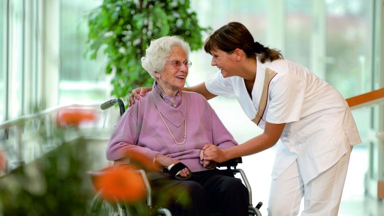 Pflegerin kümmert sich um ältere Dame im Pflegeheim.